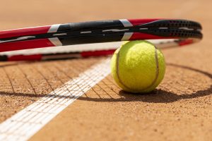primer-plano-raqueta-de-tenis-sobre-pelota